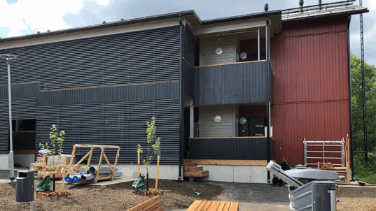 Kaksikerroksinen ruskea rivitalo.