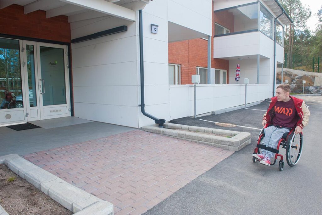 Aurinkopihan asiakas yksikön pihalla pyörätuolissa.