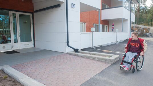 Aurinkopihan asiakas yksikön pihalla pyörätuolissa.