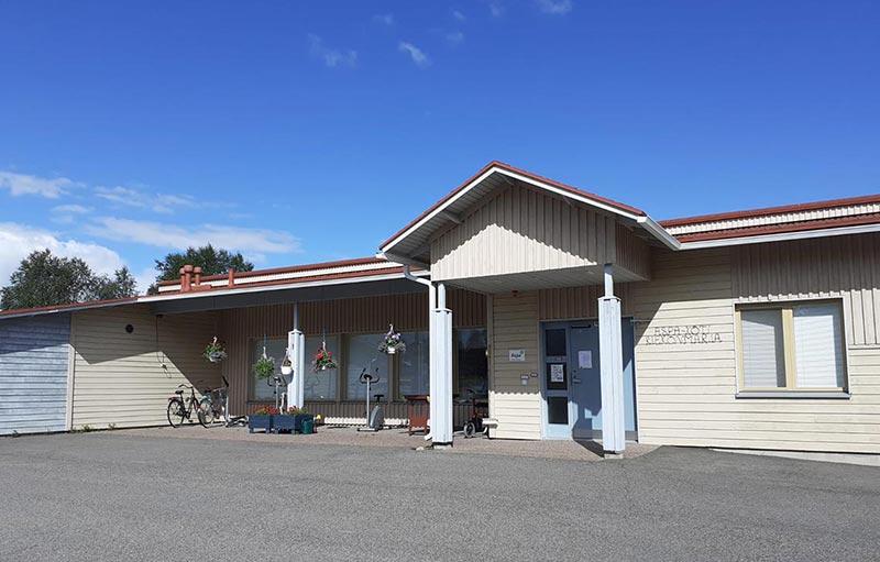 Valkoinen rakennus ja yksikön sisäänkäynti.