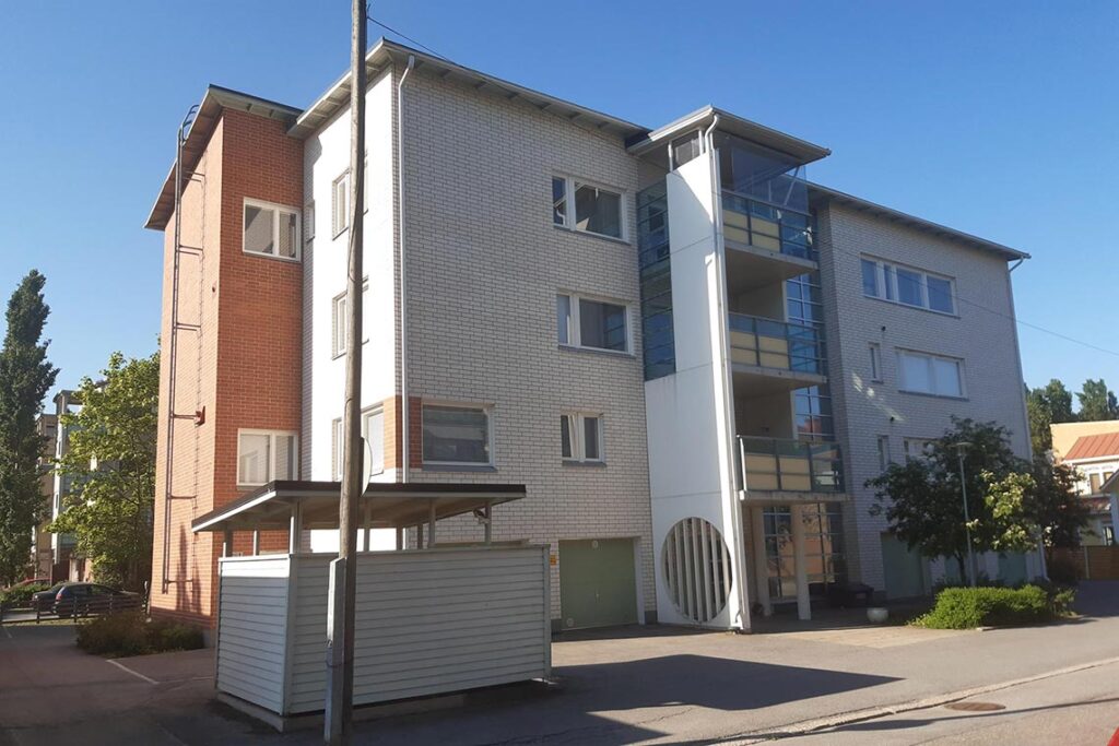 Valkoinen tiilikerrostalo.