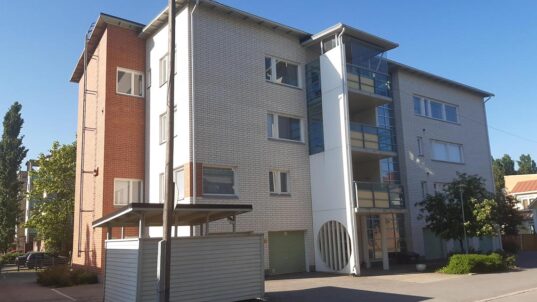 Valkoinen tiilikerrostalo.