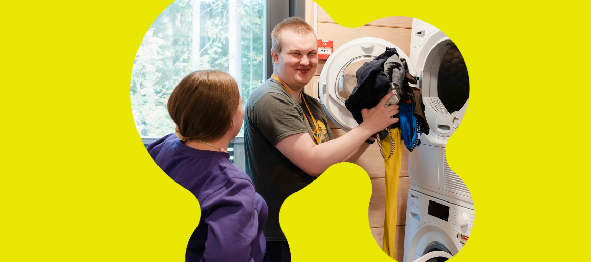 Aleksi laittaa pyykkiä pesukoneeseen.