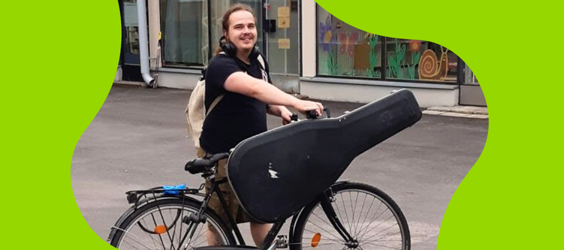 Mies polkupyörän ja kitaran kanssa.