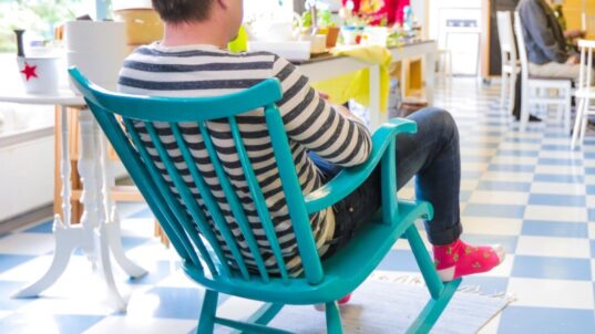 Mies istuu keinutuolissa.