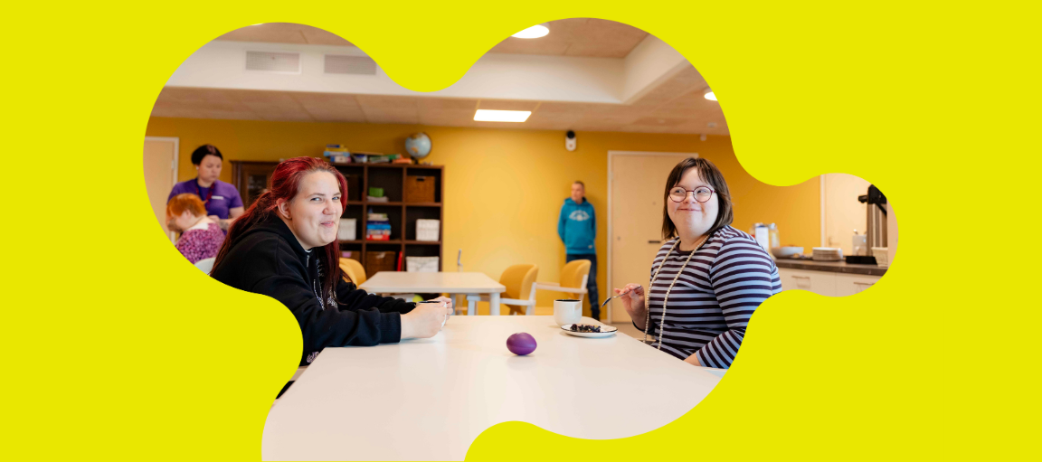 Kaksi nuorta naista istuvat kahvipöydän ääressä.