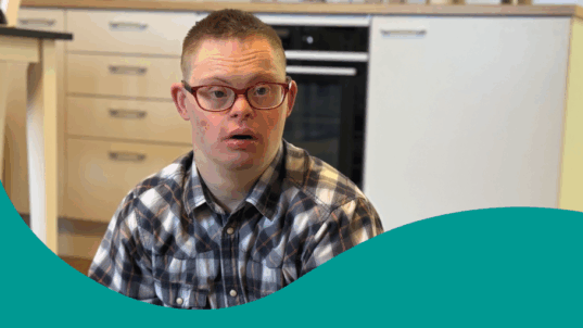 Mies istuu lattialla huoneessaan.