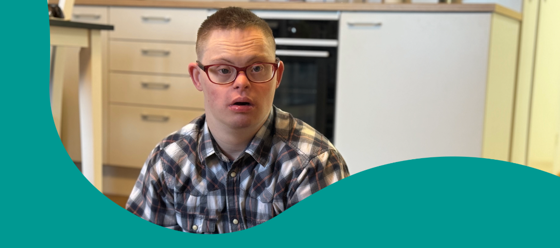 Mies istuu lattialla huoneessaan.