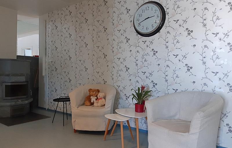 Oleskelutila, jossa valkoiset nojatuolit.