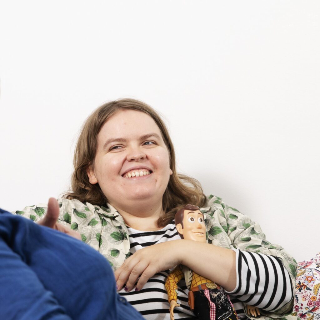 Nainen hymyilee ja halaa pehmolelua.