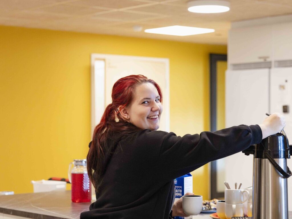 Tavanan asiakas ottamassa kahvia termoskannusta.