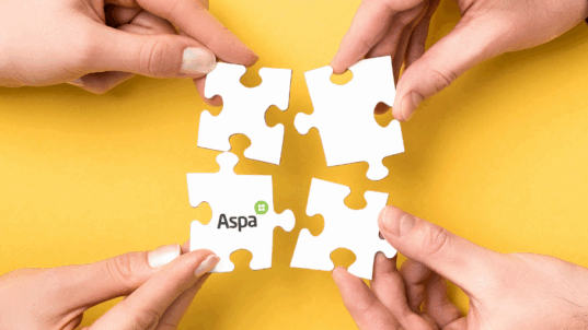 Neljä kättä yhdistää palapelin paloja yhteen.