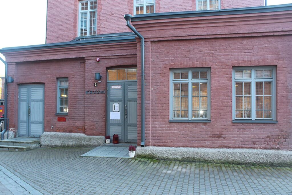 Punatiilinen rakennus harmaalla ovella.