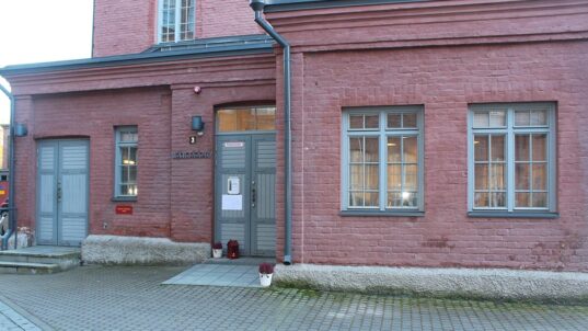 Punatiilinen rakennus harmaalla ovella.