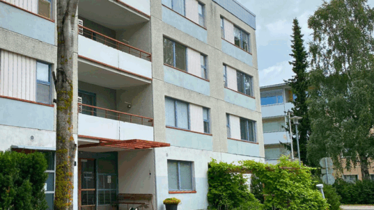 Siniharmaa kerrostalo.