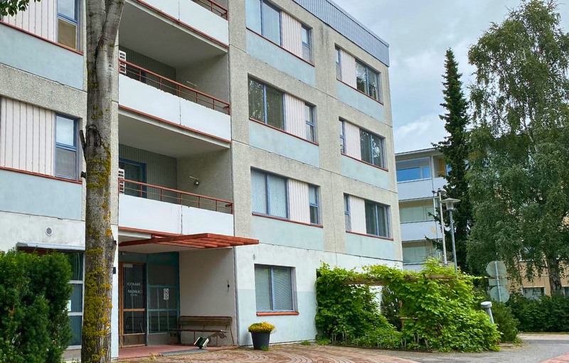 Siniharmaa kerrostalo.