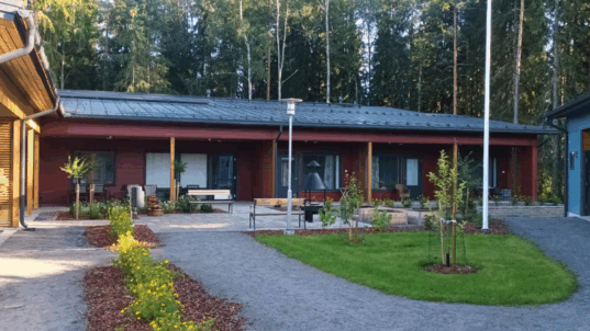 Punainen hirsinen rivitalo.