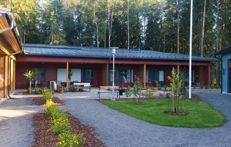 Punainen hirsinen rivitalo.