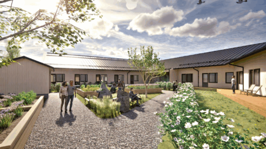 Ikäihmisten asumisyksikön visualisointi pihalta, jossa näkee rakennukset ja puutarhan.